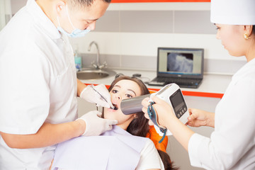 Naklejka na ściany i meble Dentist doctor doing dental treatment and using x-ray computer