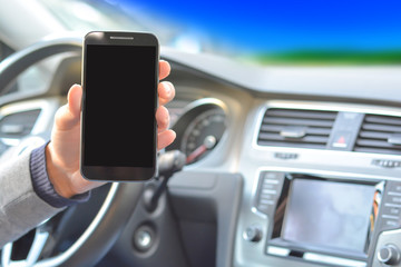 Smartphone hold by man inside a car while driving