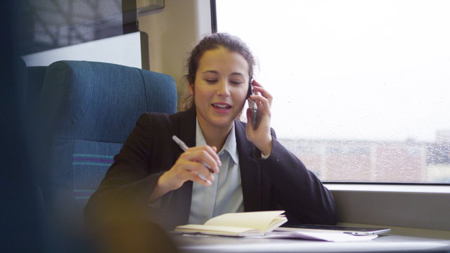  Confident businesswoman on mobile phone on a train