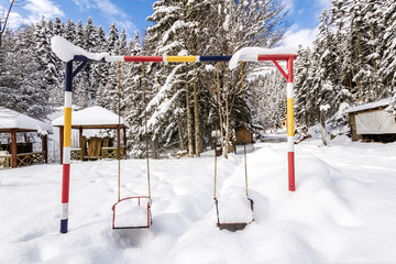 Children Playground Under Snow in the Winter Time