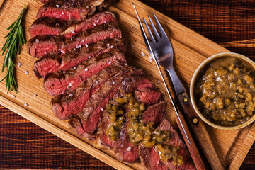 Ribeye steak and mustard sauce with pickles.