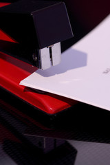 Obraz premium Stapler document / Stapler and document reflected on dark background