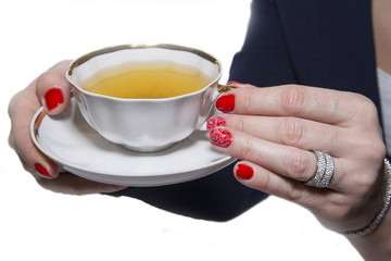 Red nail art manicure and a cup of tea.