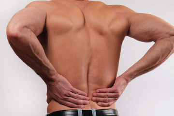 Close up of man holding his lower back. Man rubbing his painful back. . Pain relief concept