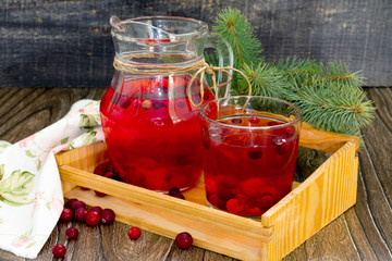 Red cranberry fruit drink, a pitcher and a glass.