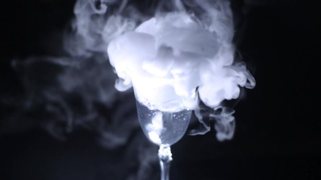 from a glass with a drink is a smoke on a black background