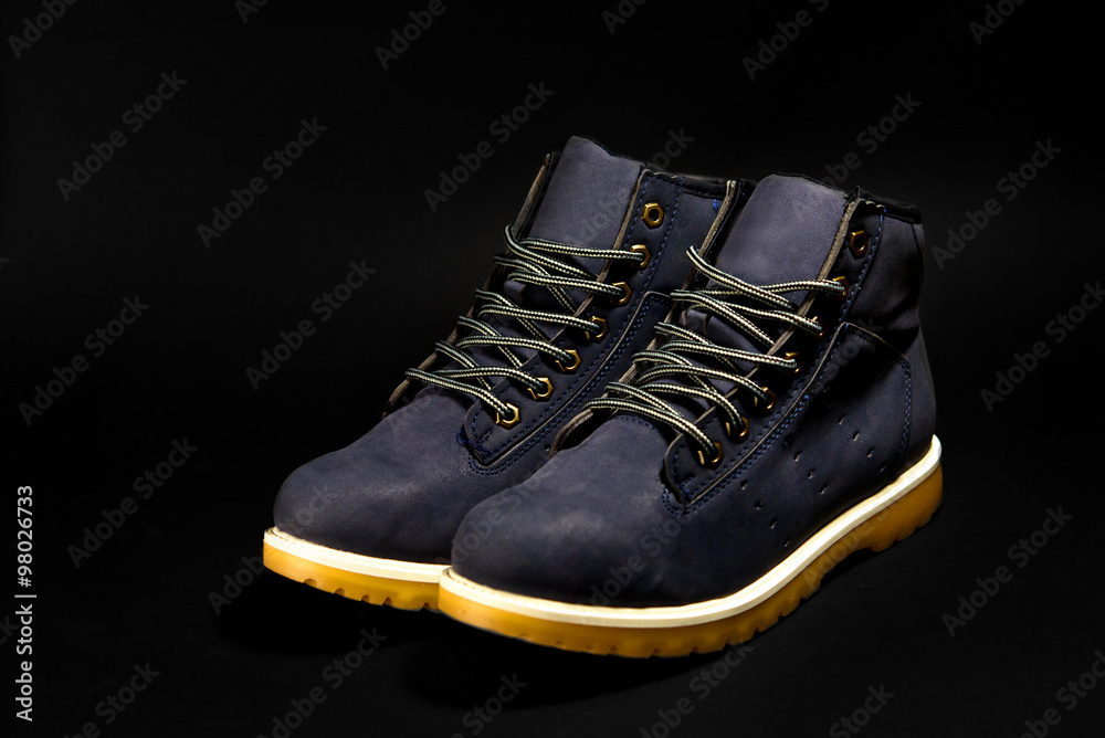 Wall mural stylish blue nubuck mens boots on black background, advertising