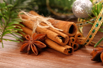 Cinnamon sticks and anise stars with decoration on wooden backgr