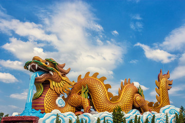 Large golden dragon statue on sky background