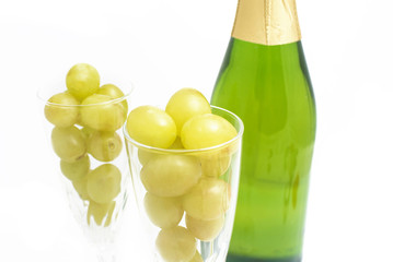 Bottle of champagne with twelve grapes of luck