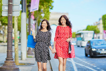 Happy twin sisters doing shopping on holidays in France