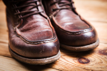 Fototapeta na wymiar Brown leather boots on wooden background