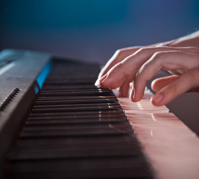 Man's hand playing piano.