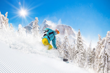 Skier skiing downhill in high mountains