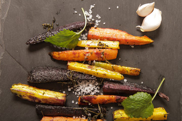 baked colorful carrots on a black background