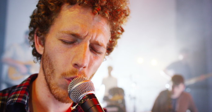  Attractive charismatic male singer performing with band at live music event