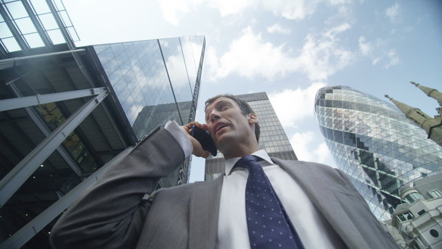  London businessman talking on smartphone punches the air having just clinched a deal. EDITORIAL.