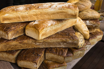 Stack of traditional bread on the street market. Assortment of baked bread.
