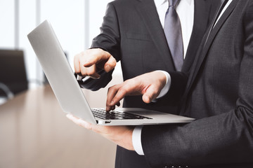 Businessman shows screen of laptop another one in conference roo