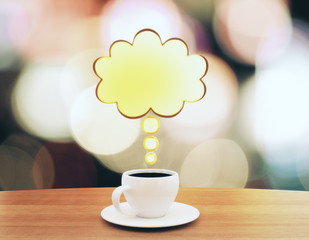 Cup of coffee with speach bubble on wooden table