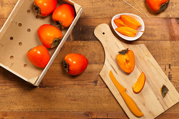 Fresh ripe persimmon on a wooden table. Selective focus.
