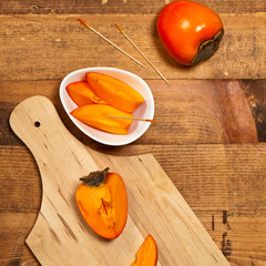 Fresh ripe persimmon on a wooden table. Selective focus.