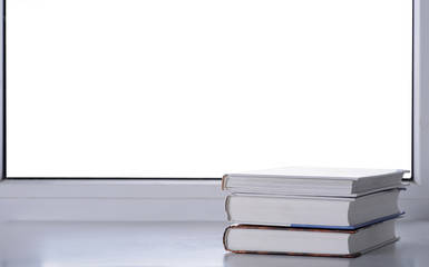 A stack of books on a windowsill with isolated background