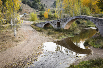 Fototapeta na wymiar Roman bridge over Pancrudo river in Luco de Jiloca, Teruel, Spain