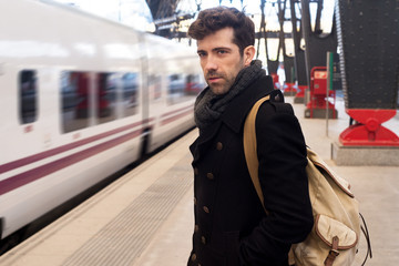 Obraz premium Young man waits for train in station