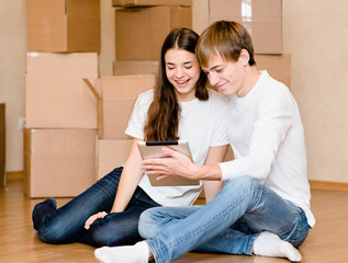 young couple using tablet computer in their new home