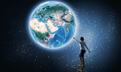 Fototapeta na wymiar Businesswoman reaching Earth planet 