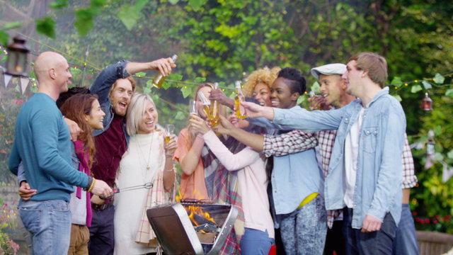  Happy group of friends at outdoor bbq raise their glasses for a toast