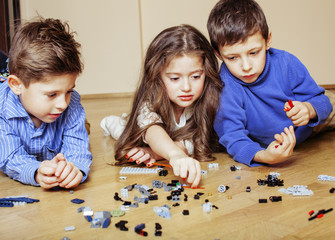 funny cute children playing Bricks at home, boys and girl smiling, first education role