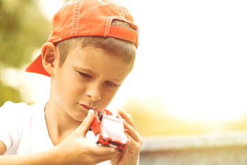 Little boy playing with toy car outside