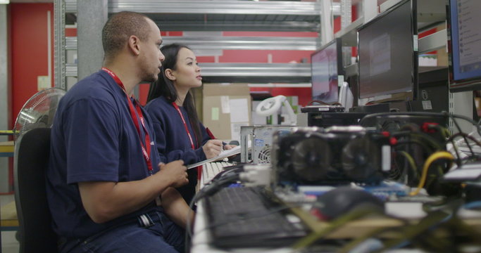 Workers in an electronics factory working on computer testing and repairs
