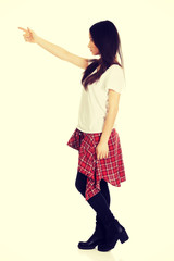 Young rock woman pointing up.