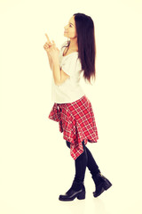 Young rock woman pointing up.