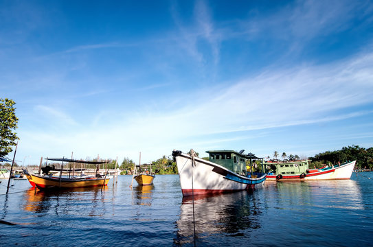 beautiful image of traditional fishing boat with reflection and blue sky at terengganu, malaysia