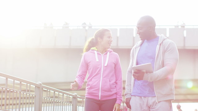  Personal trainer high fives his female client to celebrate her improvement