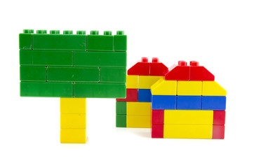 Fototapeta premium two home icon made from plastic building blocks and green signage isolated on white background