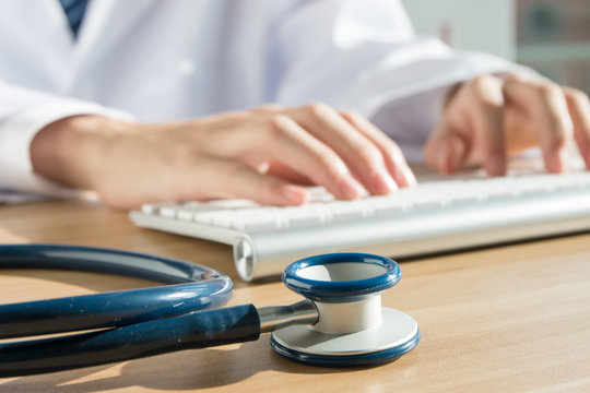 Close up of doctor's hand at computer typing