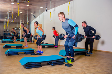 Sport, fitness, lifestyle and people concept - group flexing muscles with barbells in gym