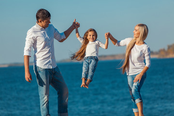 Fototapeta premium Szczęśliwa rodzina, która gra na plaży. Koncepcja przyjaznych rodzin