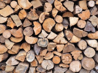 Background of dry chopped firewood logs in a pile.
