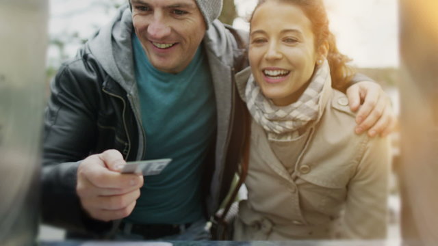 Cheerful Couple Taking Money From ATM Machine