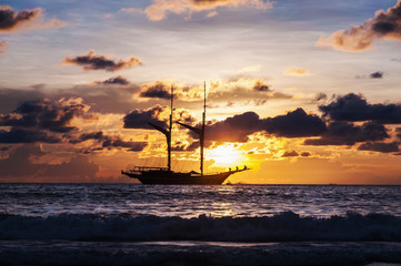 Dramatic sea and transport boat in color of sunset