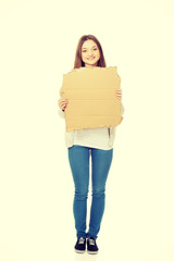 Teen woman holding cardboard sheet.