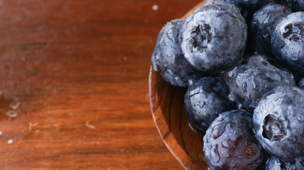 Big ripe blueberries on a wooden spoon, selective focus