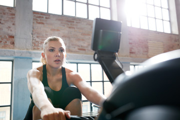 Female working out on a rowing machine at the gym