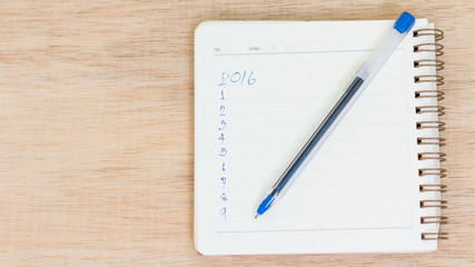 Goals for 2016 - checklist on notepad with pen on wooden backgro